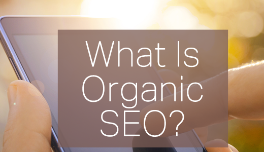 A close up of a hand holding a mobile phone, with the name of the article superimposed "What is Organic SEO?"